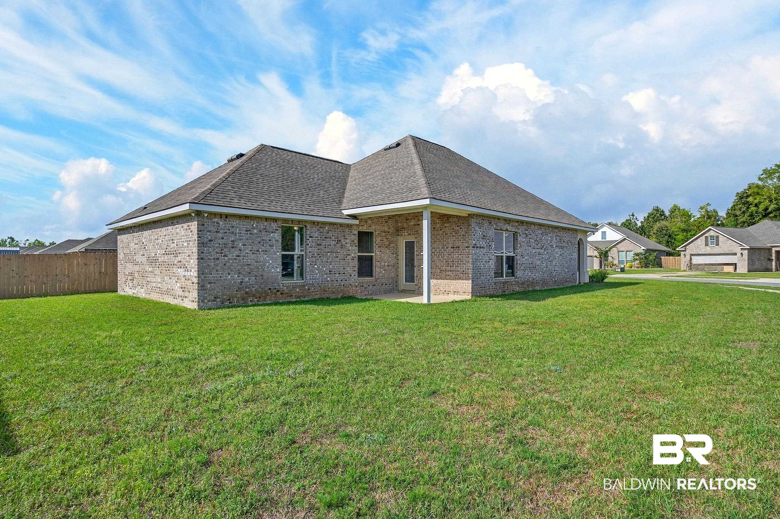 1084 Stella Road Foley, AL 36535 - Photo 3 of 31 Back of house with brick siding, a patio, a yard, and roof with shingles