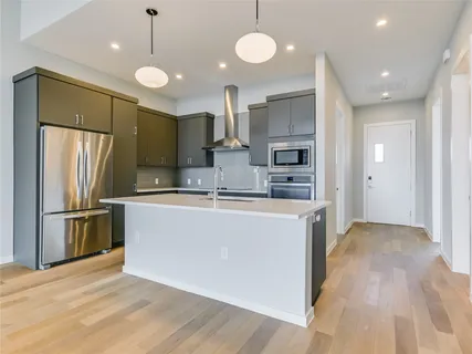 a kitchen with stainless steel appliances kitchen island a refrigerator and a stove top oven