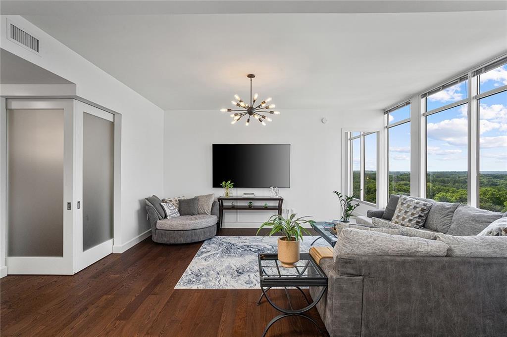 1820 Peachtree Road Northwest, Unit 1509 Atlanta, GA 30309 - Photo 20 of 61 a living room with furniture a chandelier and a flat screen tv