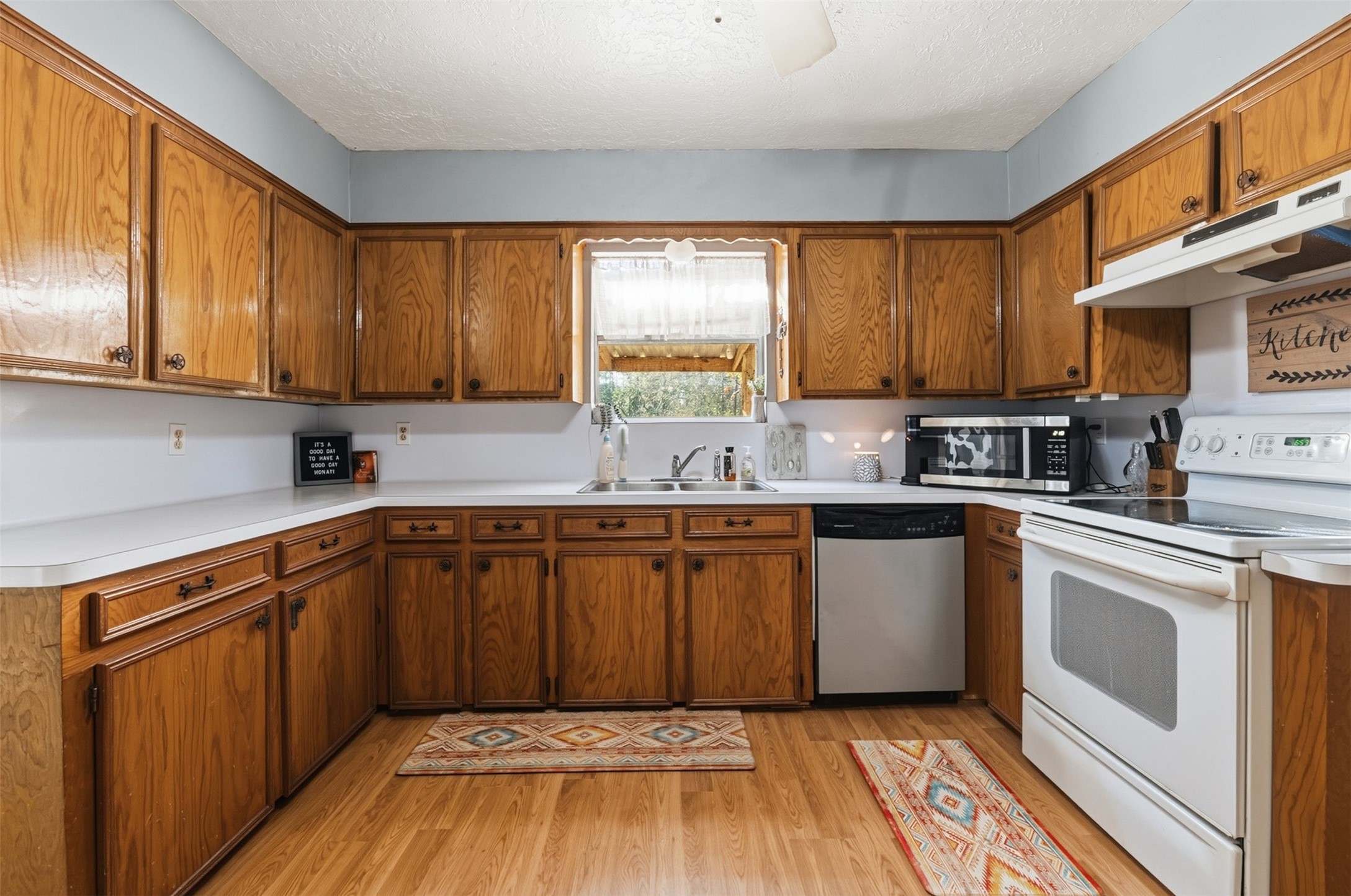 4027 Spring Branch Road Montgomery, TX 77316 - Photo 16 of 32 a kitchen with granite countertop wooden cabinets a sink and dishwasher a stove top oven with wooden floor