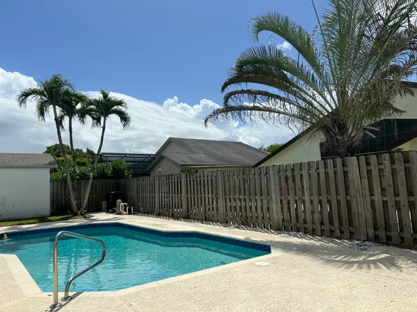 a view of a house with backyard and tree in it