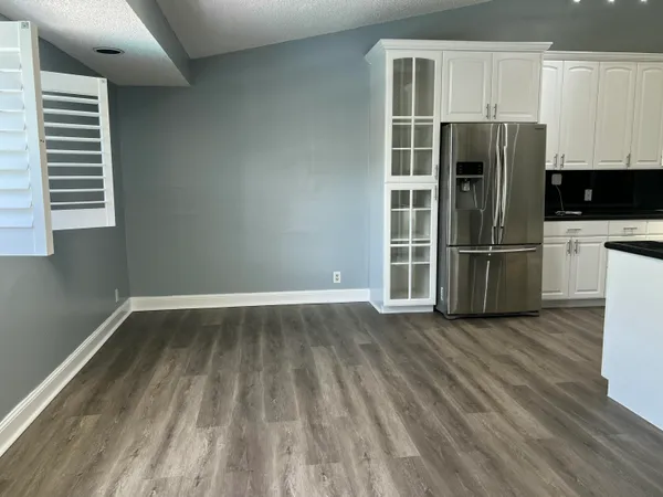 a view of a kitchen with wooden floor and a refrigerator