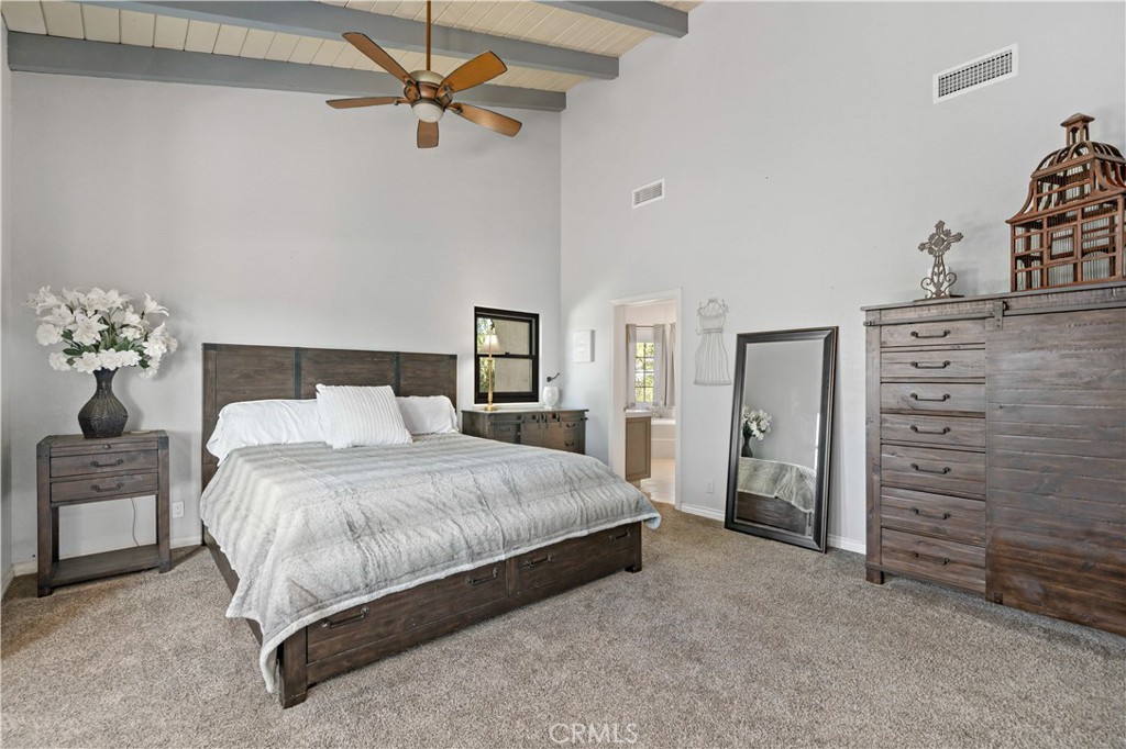 40430 Parado Del Sol Drive Temecula, CA 92592 - Photo 31 of 75 a spacious bedroom with a bed and a chandelier