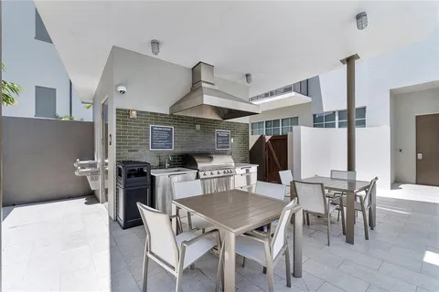 a kitchen with stainless steel appliances kitchen island granite countertop a dining table and chairs