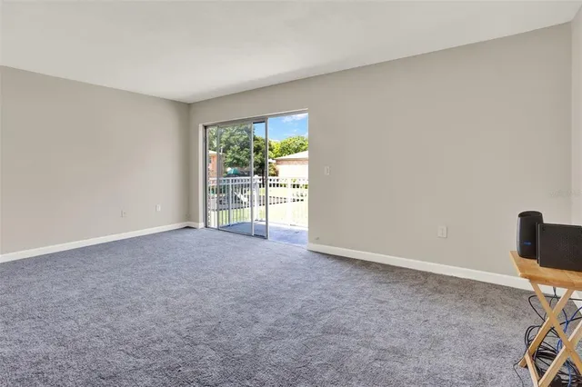 an empty room with a ceiling fan and window
