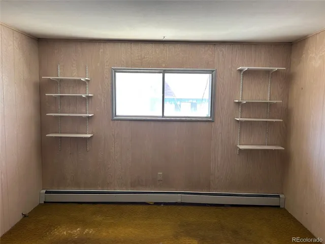 an empty room with a wooden floor and windows