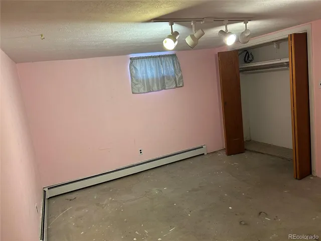a view of an empty room with a chandelier fan