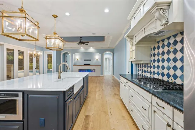 a living room with stainless steel appliances furniture a rug and a large window