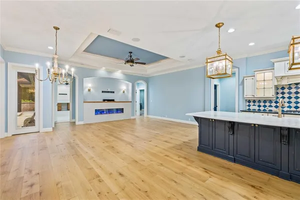 a living room with stainless steel appliances furniture a rug and a large window