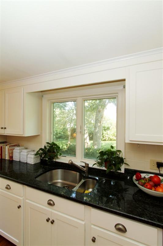 138 Long Road Harwich, MA 02645 - Photo 7 of 33 a kitchen with granite countertop a sink a stove and white cabinets
