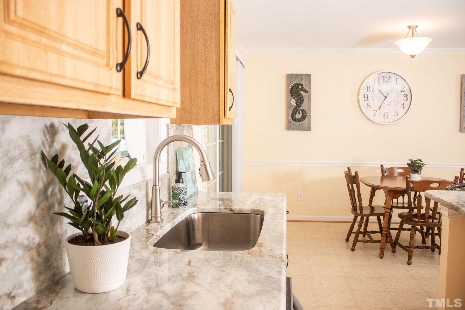 260 Waters Edge Loop Henderson, NC 27537 - Photo 15 of 38 a view of a dining room with furniture and a potted plant