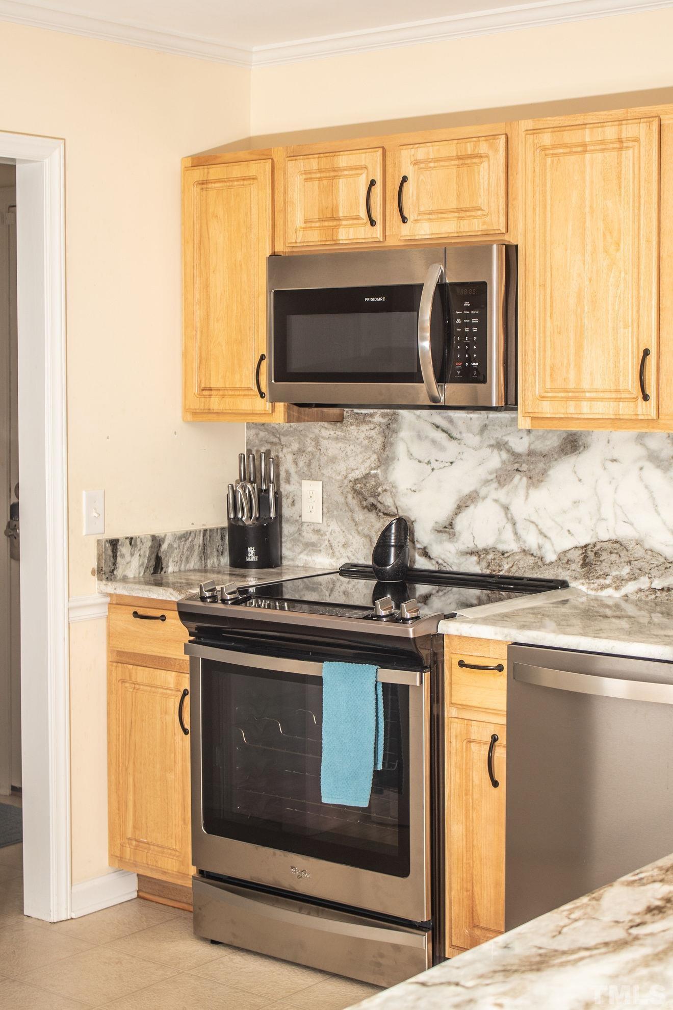 260 Waters Edge Loop Henderson, NC 27537 - Photo 16 of 38 a kitchen with stainless steel appliances granite countertop a stove and a microwave