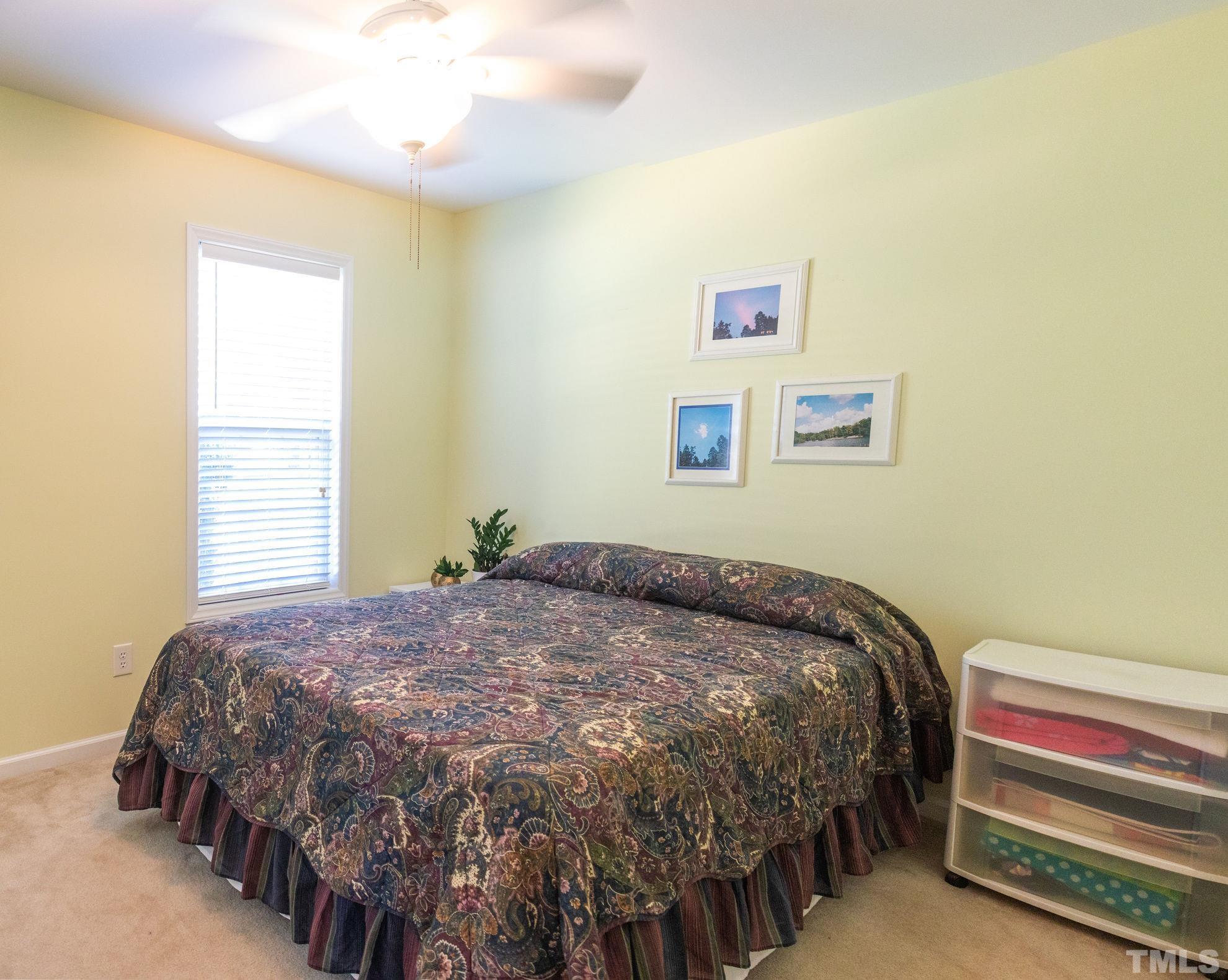 260 Waters Edge Loop Henderson, NC 27537 - Photo 22 of 38 a bedroom with a bed and a chandelier