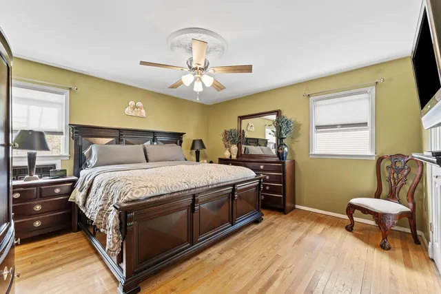 a bedroom with a bed and a chair with the wooden floor