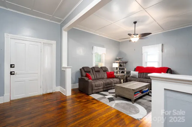 a living room with furniture a flat screen tv and a window