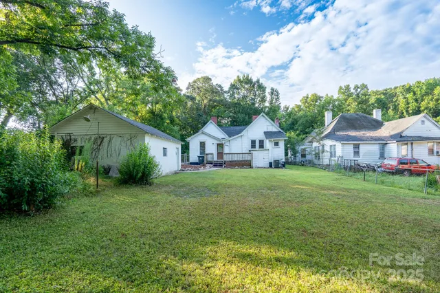 a front view of a house with yard and tree