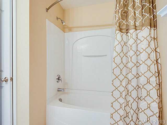 10628 Pointer Ridge Drive Charlotte, NC 28214 - Photo 11 of 16 a white bath tub with a shower curtain