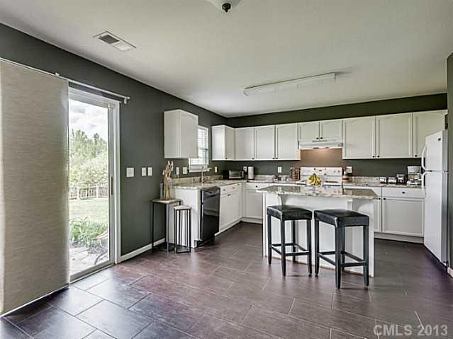 10628 Pointer Ridge Drive Charlotte, NC 28214 - Photo 7 of 16 a kitchen with white cabinets and appliances