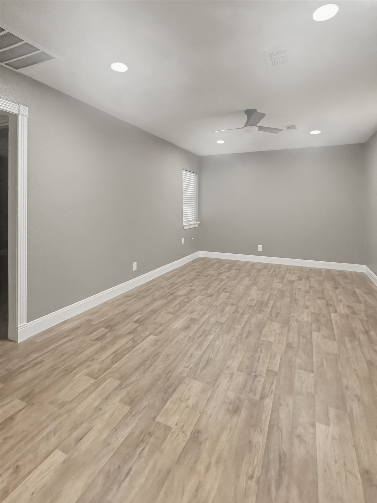 1308 North Rockisland Street Angleton, TX 77515 - Photo 4 of 13 an empty room with wooden floor and windows