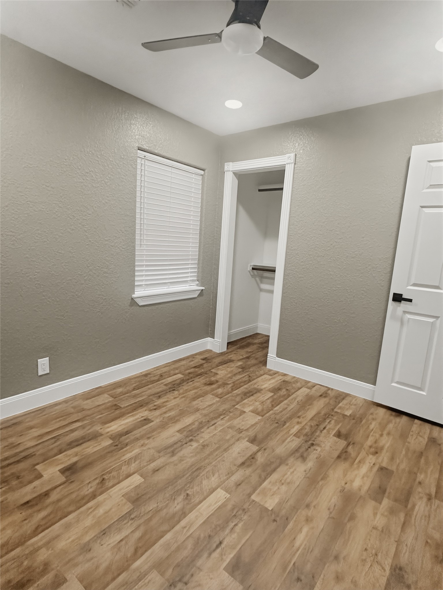 1308 North Rockisland Street Angleton, TX 77515 - Photo 9 of 13 an empty room with wooden floor and windows