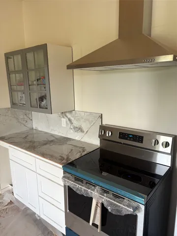 a stove top oven sitting inside of a kitchen