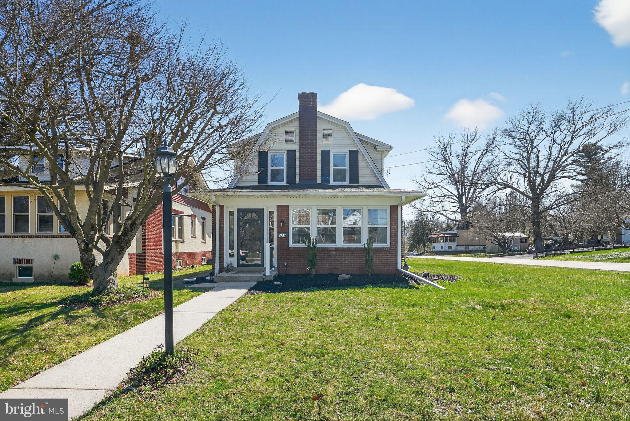 a view of a house with a yard and large tree