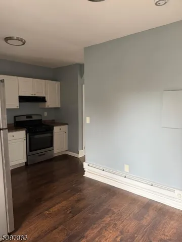 a view of kitchen with wooden floor and electronic appliances