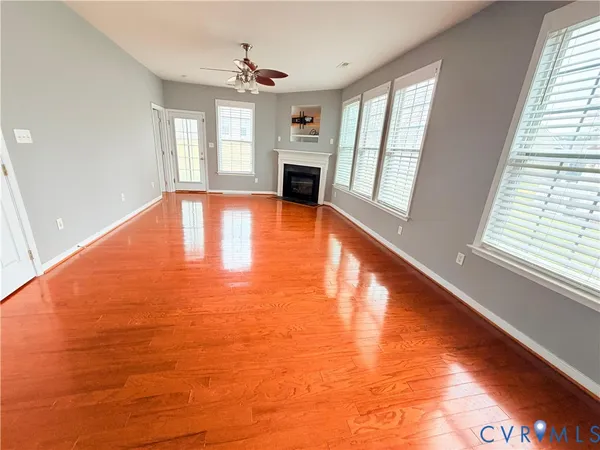 a view of an empty room with window and wooden floor