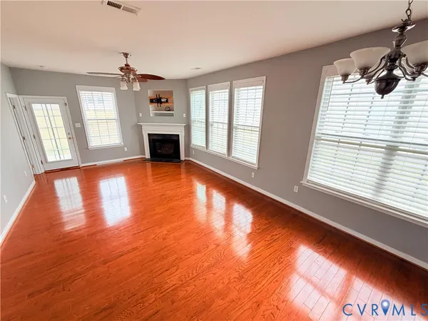 a view of a livingroom with wooden floor and a fireplace