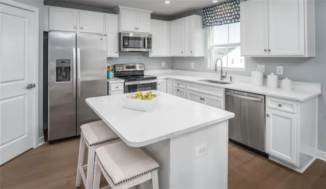 a kitchen with a sink a stove a refrigerator and white cabinets