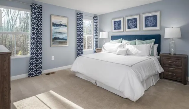 a large bed sitting in a bedroom and painting on the wall