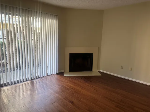 an empty room with wooden floor and fireplace
