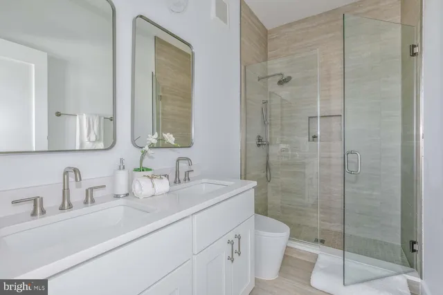 a bathroom with a sink a toilet and shower