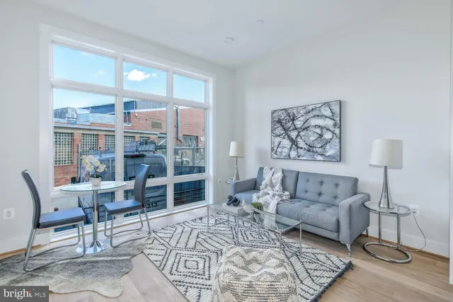 a living room with furniture a rug and a large window