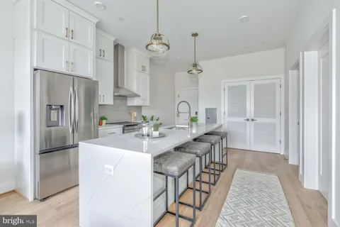 a kitchen with stainless steel appliances kitchen island a refrigerator and a stove