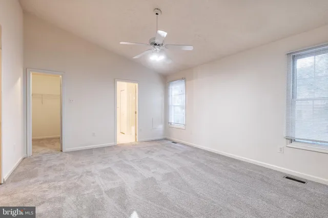 an empty room with fan and windows