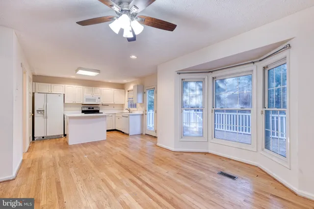 a view of kitchen with granite countertop cabinets and refrigerator