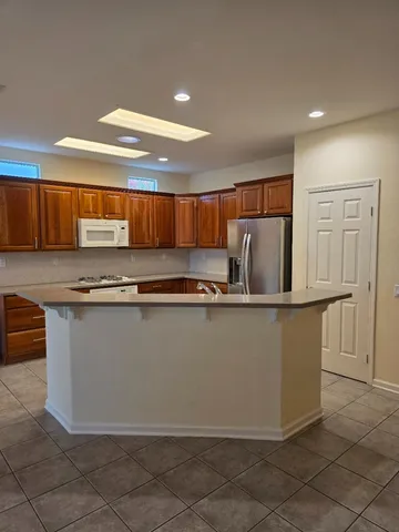 a kitchen with stainless steel appliances granite countertop a refrigerator a sink and a stove