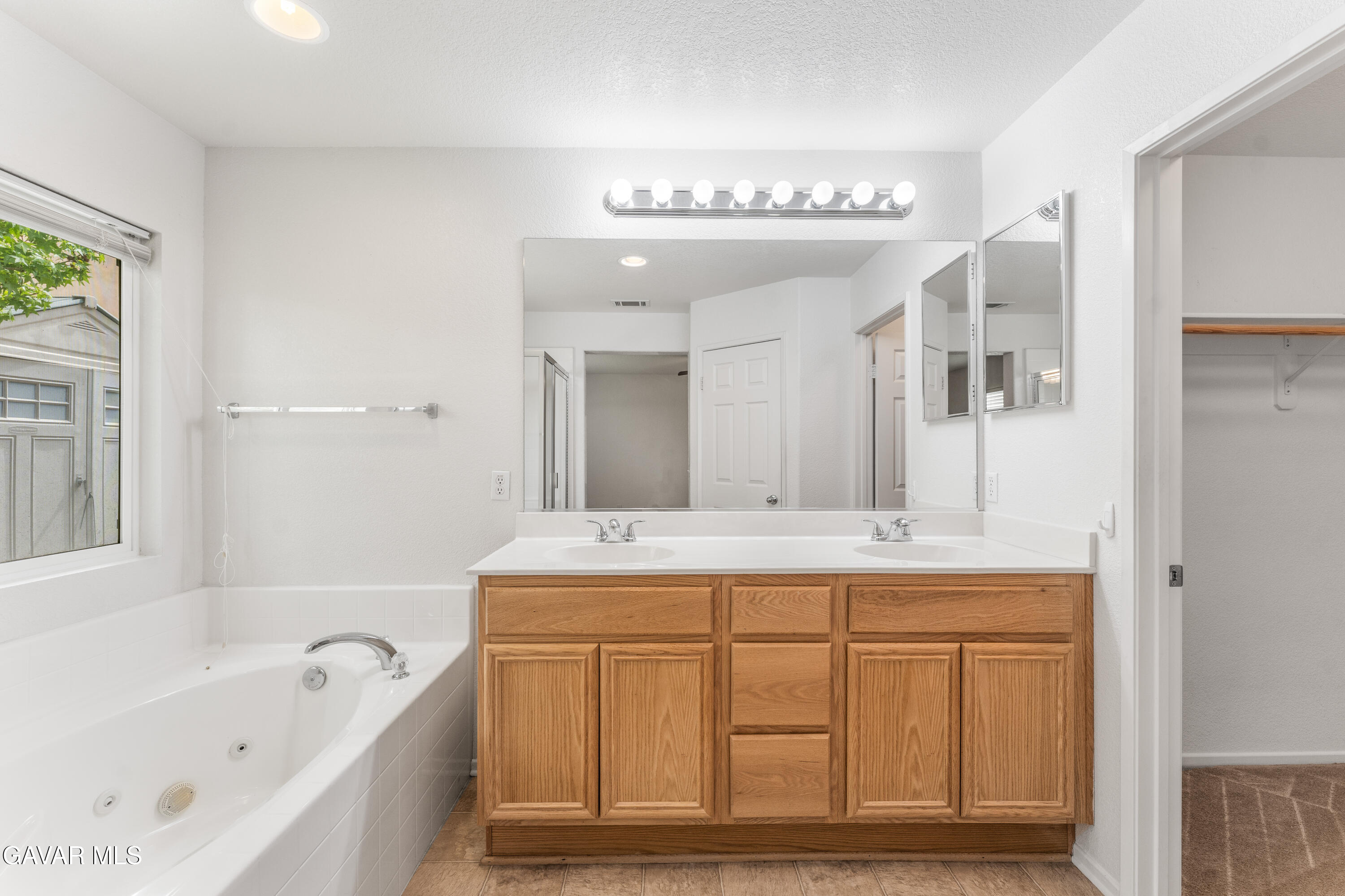 45334 Stadium Lane Lancaster, CA 93535 - Photo 15 of 36 a spacious bathroom with a tub sink and mirror