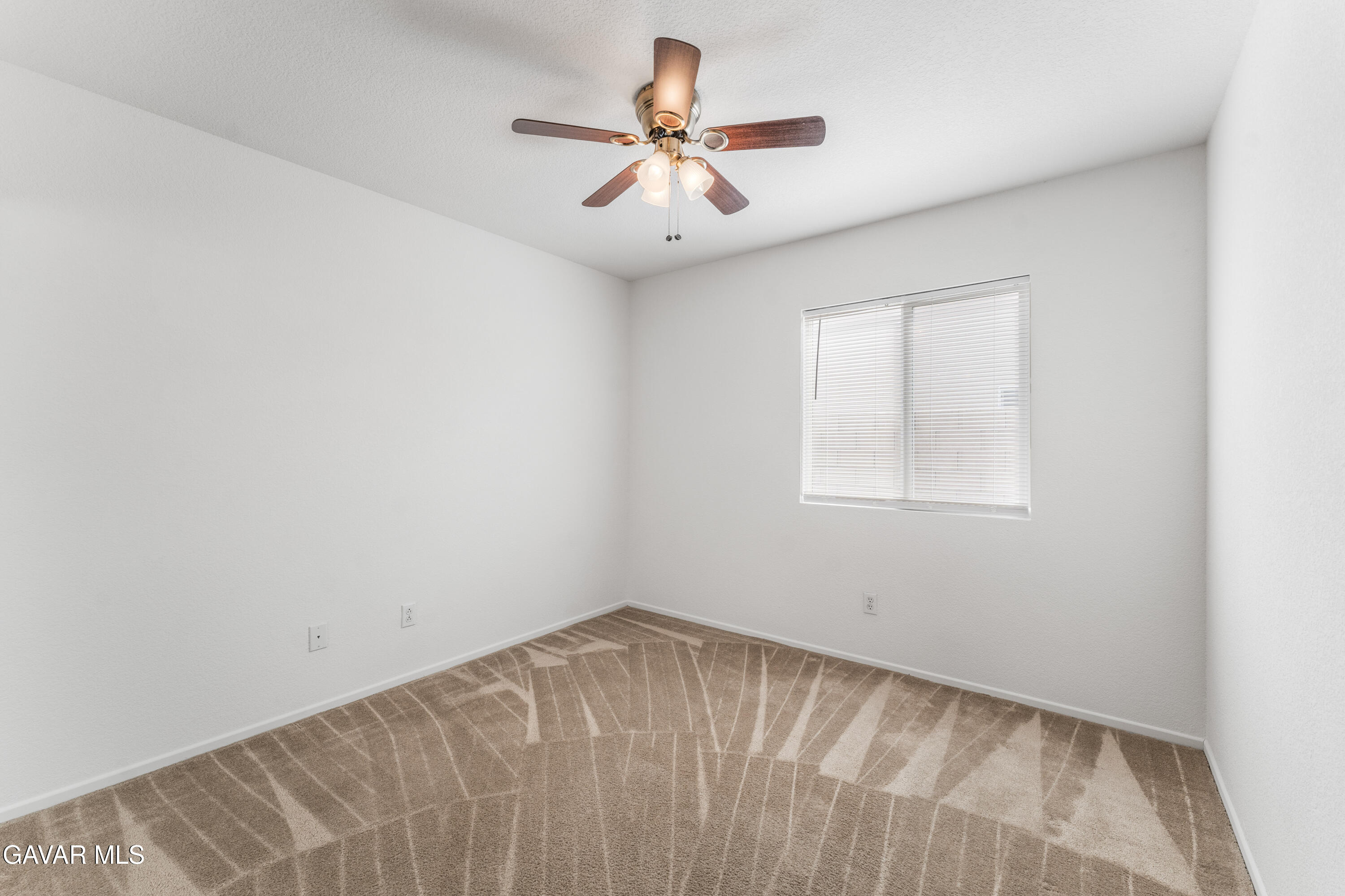 45334 Stadium Lane Lancaster, CA 93535 - Photo 18 of 36 an empty room with a window and a ceiling fan