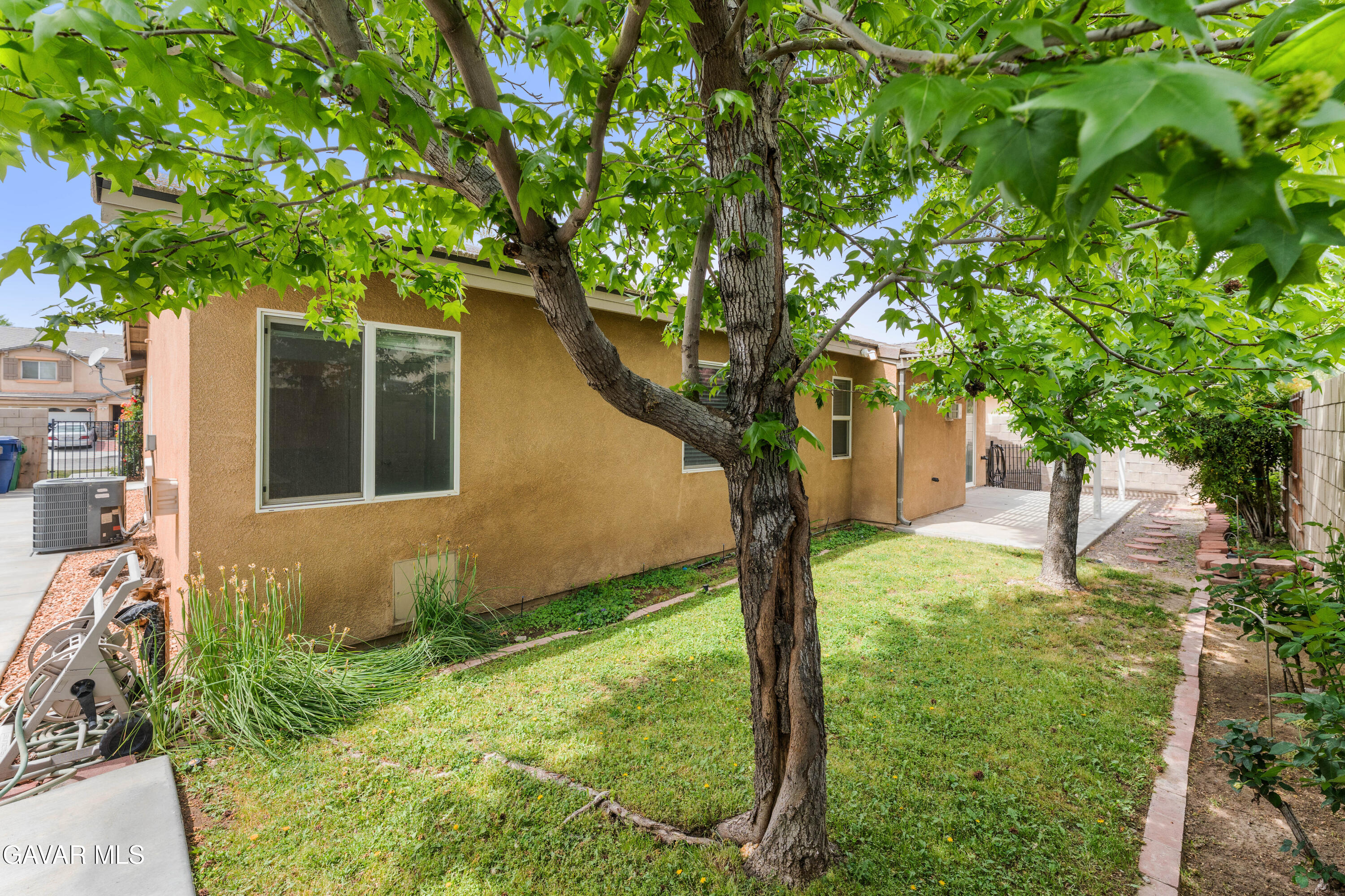 45334 Stadium Lane Lancaster, CA 93535 - Photo 33 of 36 a tree in front of a house next to a yard