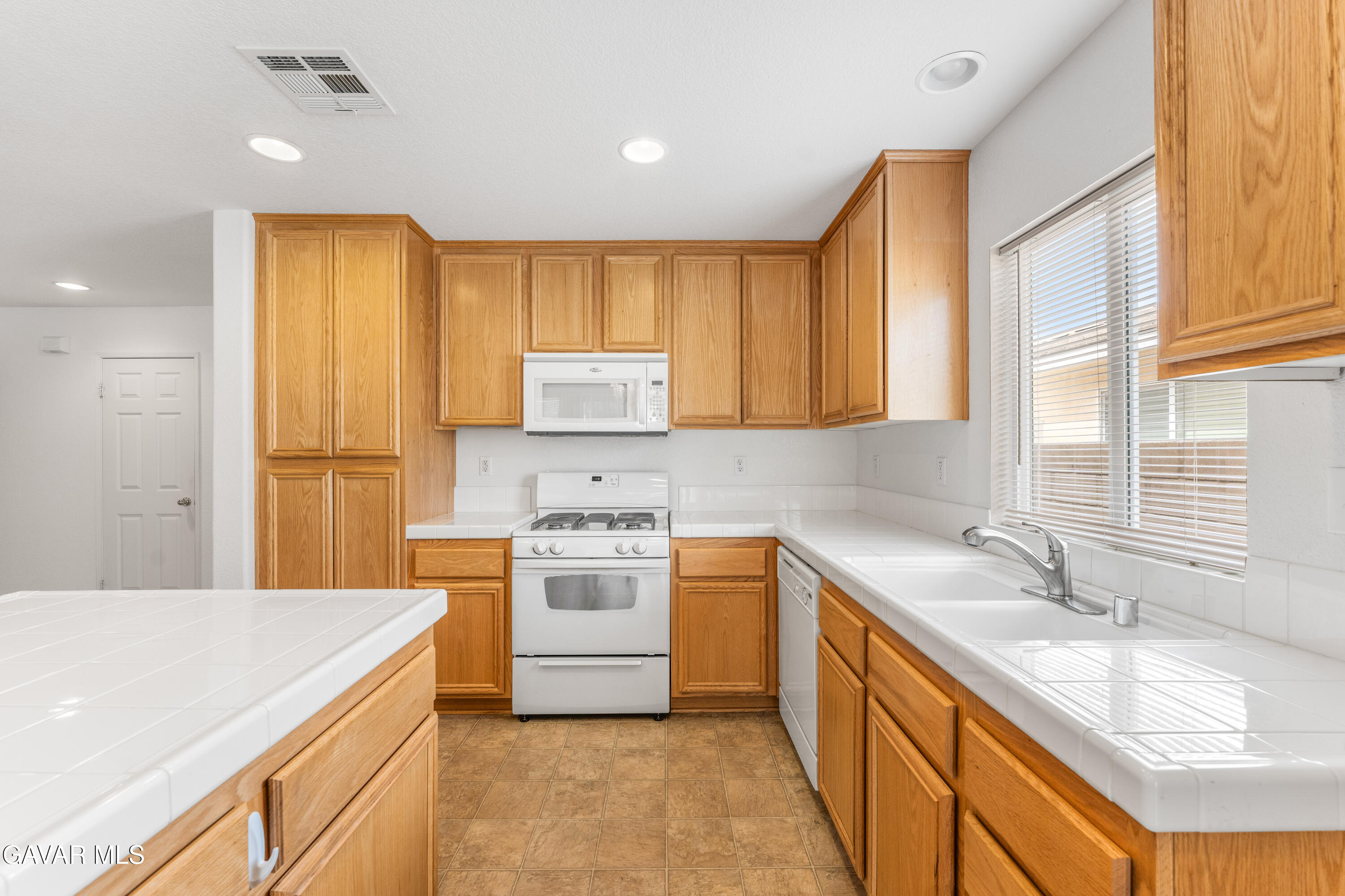 45334 Stadium Lane Lancaster, CA 93535 - Photo 10 of 36 a kitchen with a sink stove top oven and refrigerator