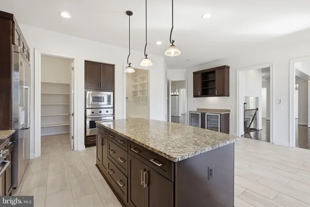 a kitchen with stainless steel appliances granite countertop a refrigerator a oven and a sink