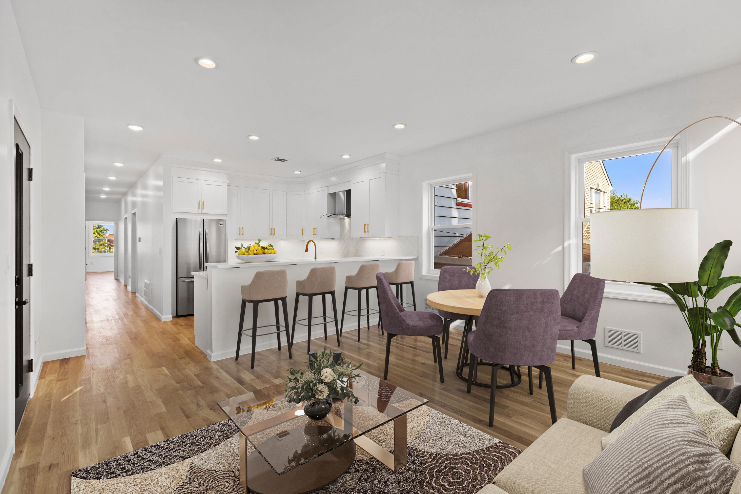 a living room with furniture and kitchen view with wooden floor