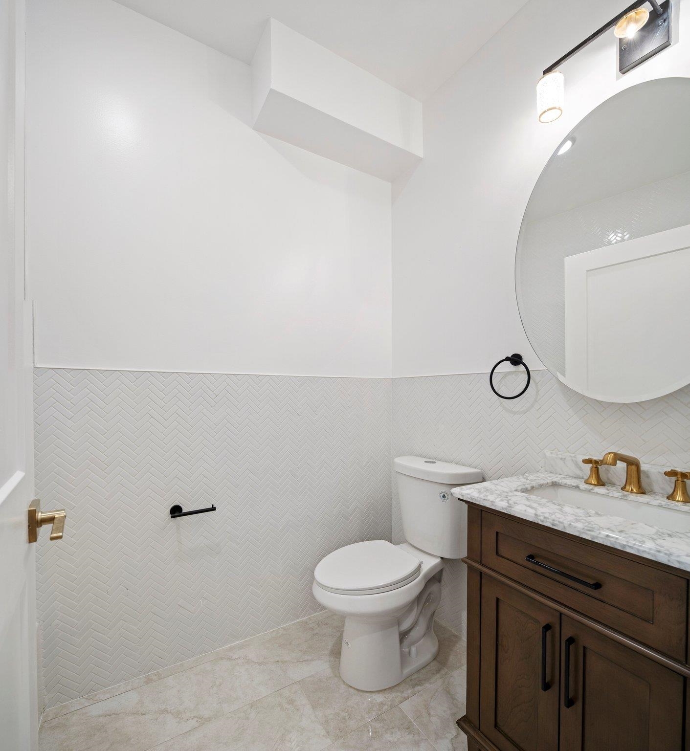30 Wilkinson Avenue, Unit 1 Jersey City, NJ 07305 - Photo 11 of 17 a bathroom with a granite countertop toilet sink mirror and vanity