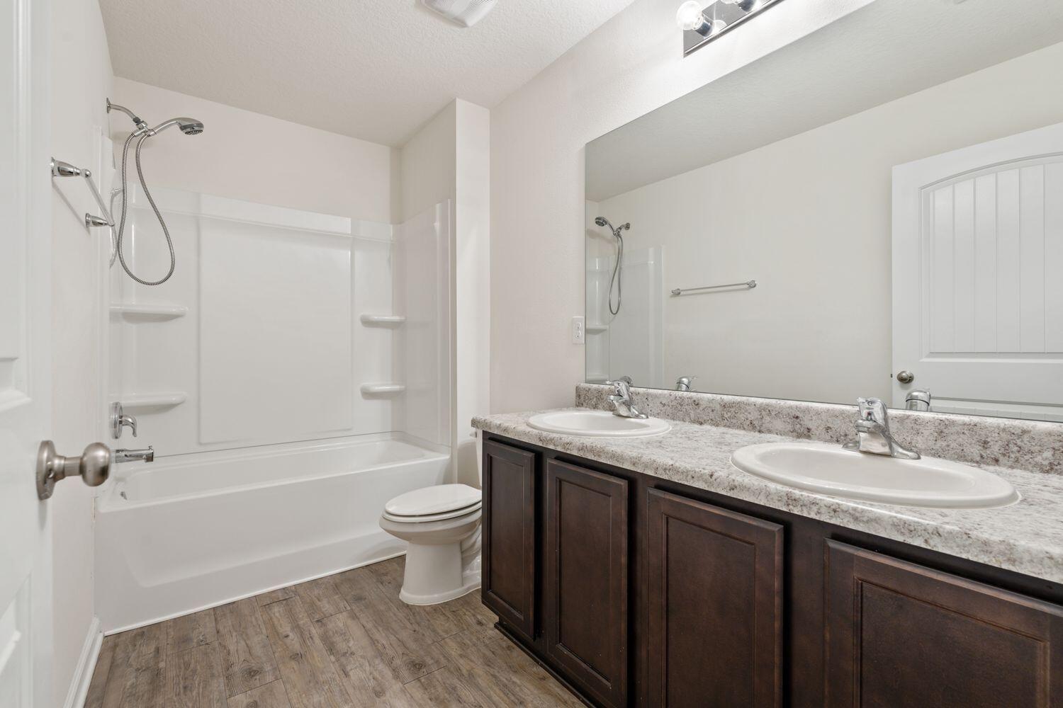737 Widgeon Way Crestview, FL 32539 - Photo 27 of 36 a bathroom with a granite countertop sink toilet and shower