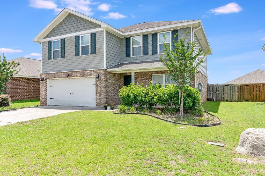 737 Widgeon Way Crestview, FL 32539 - Photo 3 of 36 a front view of a house with a yard and garage