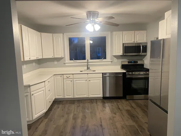 a kitchen with granite countertop a sink stainless steel appliances and cabinets