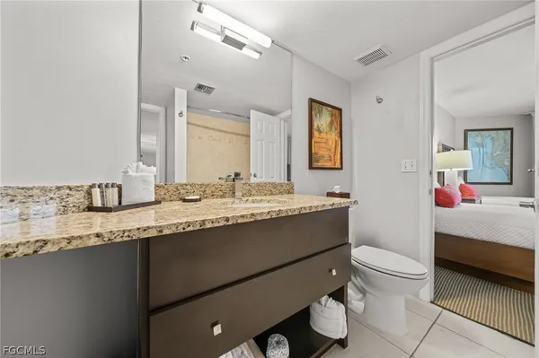a bathroom with a granite countertop sink mirror vanity and toilet