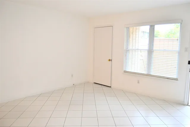 an empty room with white walls and tiles